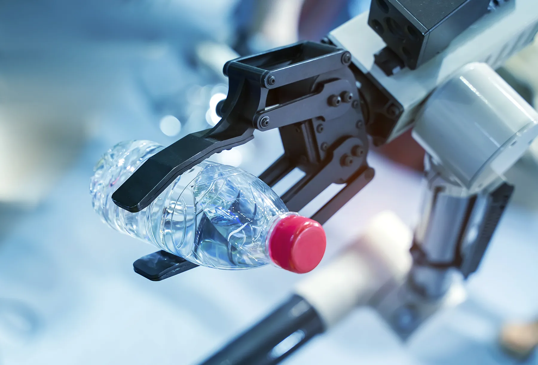 Robotic arm moves recycling on an automated factory line.
